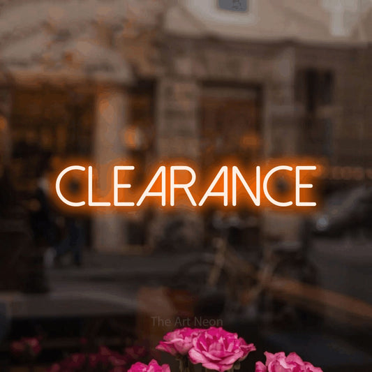 Orange LED neon sign reading "Clearance" in a softly blurred café interior