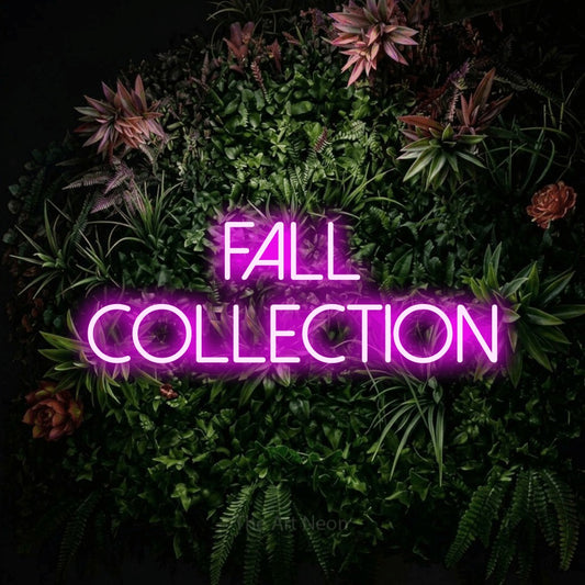 Pink LED neon sign reading "Fall Collection" against a flowering garden wall