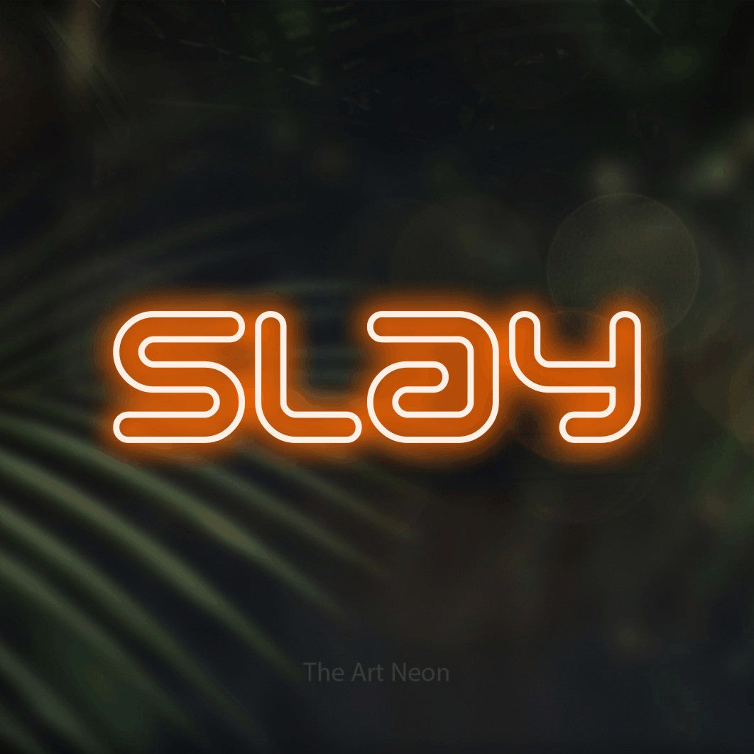 Orange outline-style LED neon sign reading "Slay" against dark blurred palm leaves