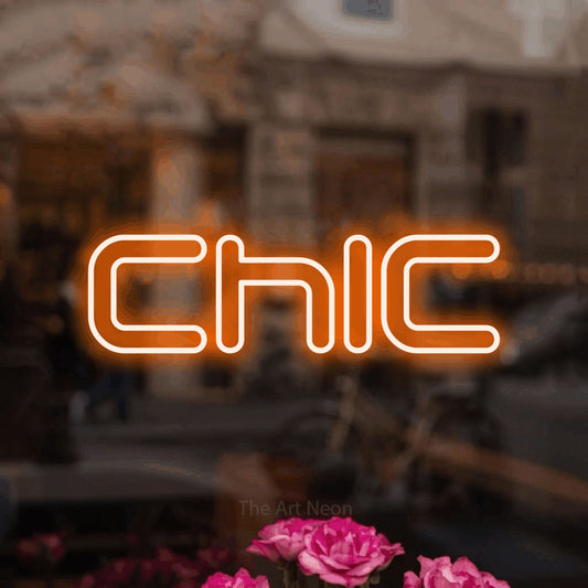 Orange outline-style LED neon sign reading "Chic" in a softly blurred café interior
