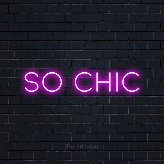 Pink LED neon sign reading "So Chic" against a dark navy brick wall