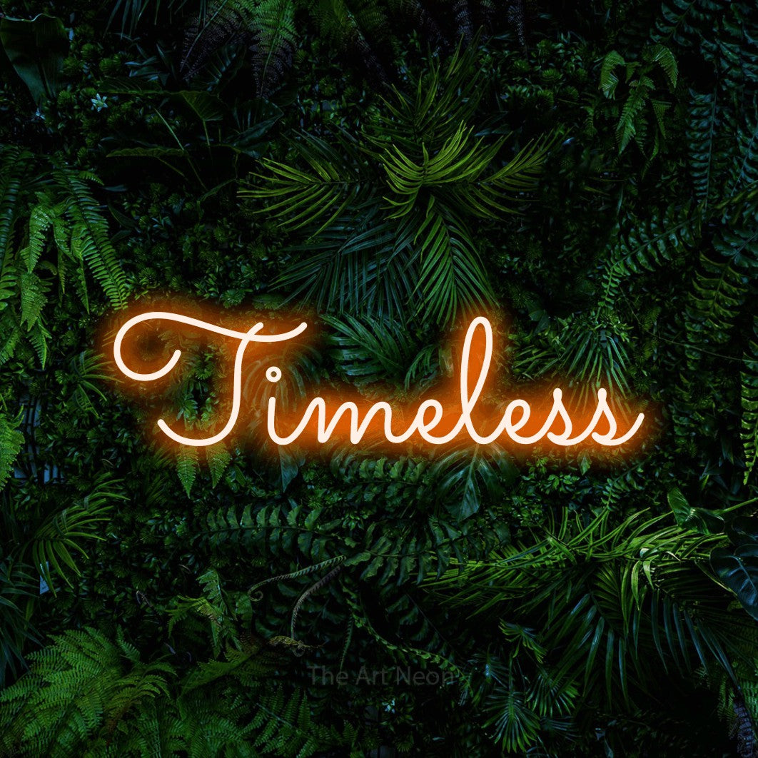 Orange LED neon sign reading "Timeless" against a dense tropical foliage wall