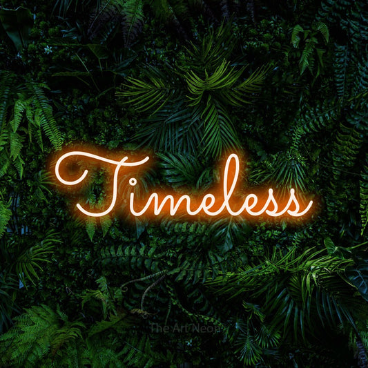 Orange LED neon sign reading "Timeless" against a dense tropical foliage wall