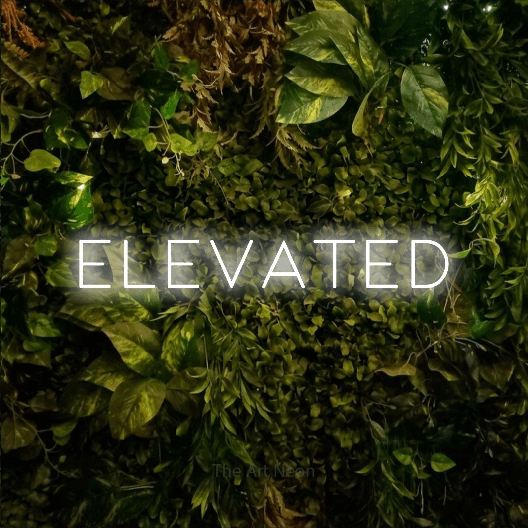 Cool white LED neon sign reading "Elevated" against a textured moss and foliage wall