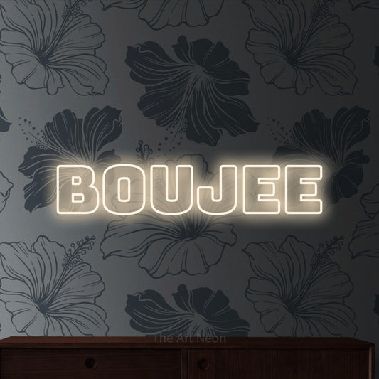 Warm white outline-style LED neon sign reading "Boujee" against grey floral wallpaper