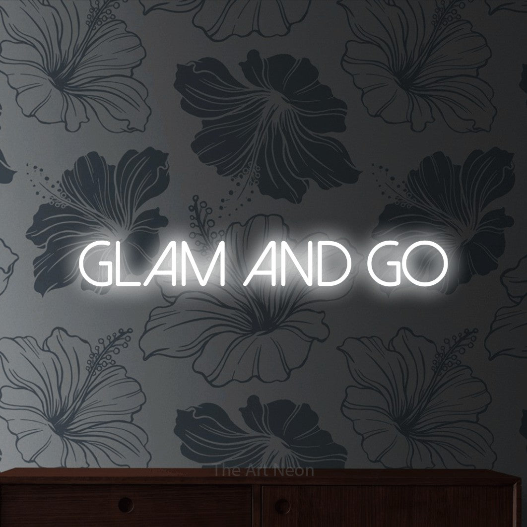 Cool white LED neon sign reading "Glam and Go" against grey floral wallpaper