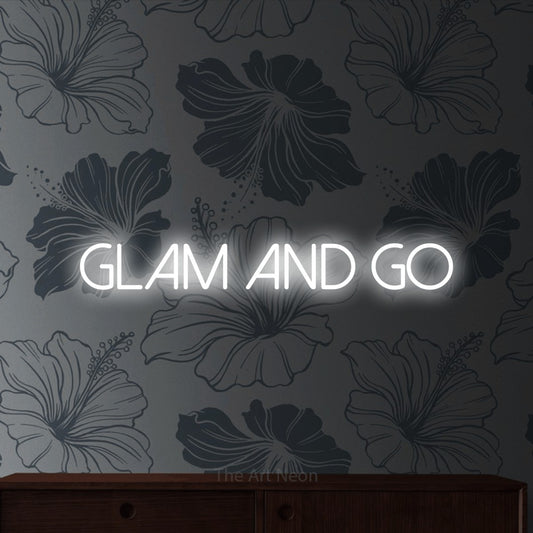 Cool white LED neon sign reading "Glam and Go" against grey floral wallpaper