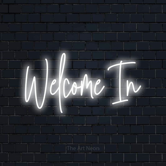 Cool white script-style LED neon sign reading "Welcome In" against a dark navy brick wall