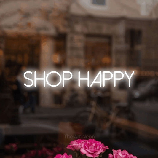 Cool white LED neon sign reading "Shop Happy" in a softly blurred café interior