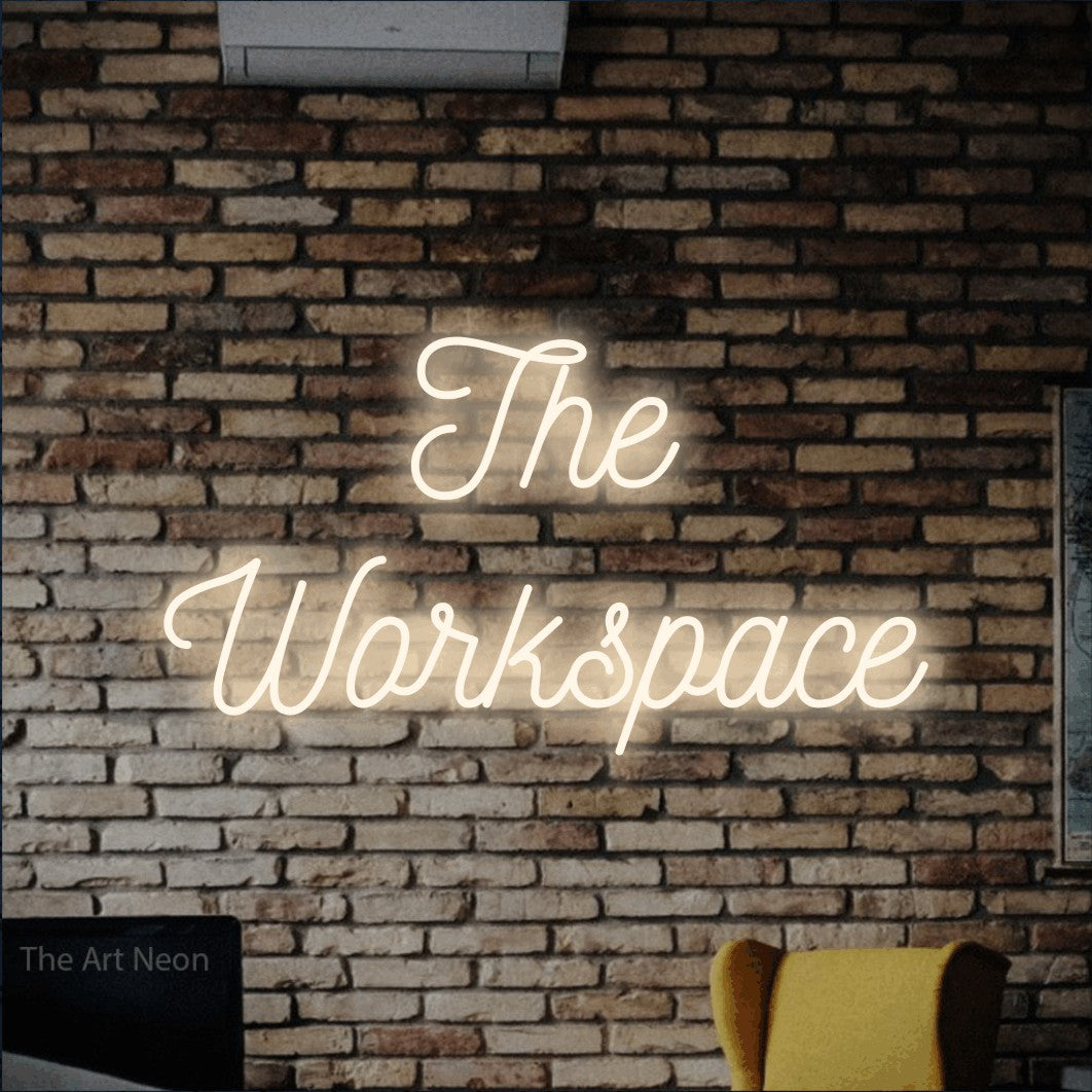 Warm white script-style LED neon sign reading "The Workspace" against a rustic brick wall for office décor