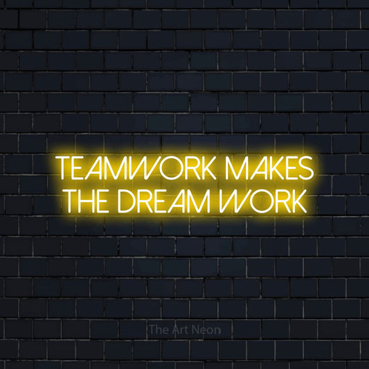 Yellow LED neon sign reading "Teamwork Makes the Dream Work" against a dark navy brick wall for office décor