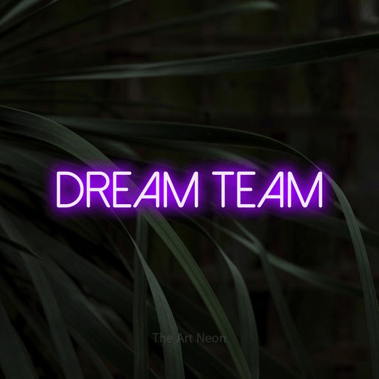 Purple LED neon sign reading "Dream Team" against dark tropical leaves for office décor