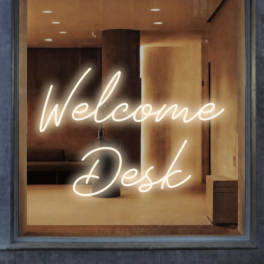 Warm white script-style LED neon sign reading "Welcome Desk" in a warm modern interior for office décor