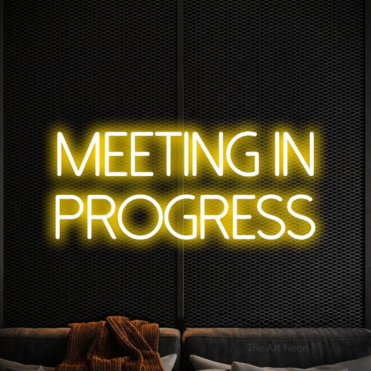 Yellow LED neon sign reading "Meeting in Progress" against a black textured wall for office décor