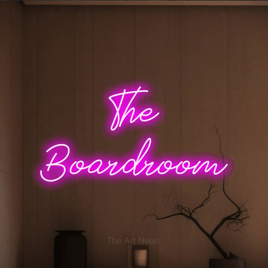 Pink script-style LED neon sign reading "The Boardroom" against a warm brown wall for office décor
