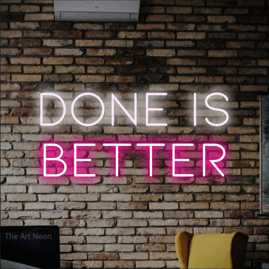 Hot pink and cool white LED neon sign reading "Done is Better" against a rustic brick wall for office décor