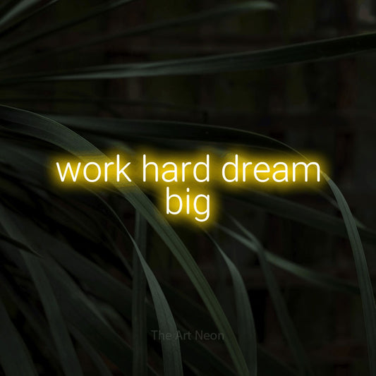 Yellow LED neon sign reading "Work Hard Dream Big" against dark tropical leaves for office décor