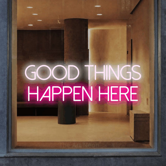 Hot pink and cool white LED neon sign reading "Good Things Happen Here" in a warm modern interior for office décor