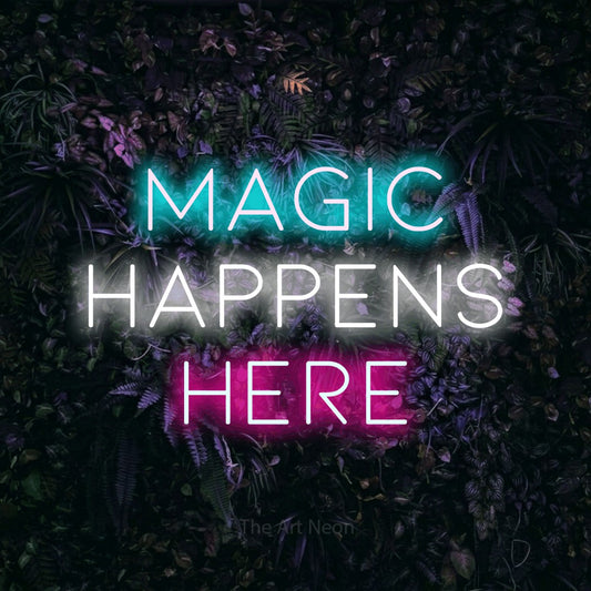 Multicolour LED neon sign reading "Magic Happens Here" against a purple floral wall for office décor
