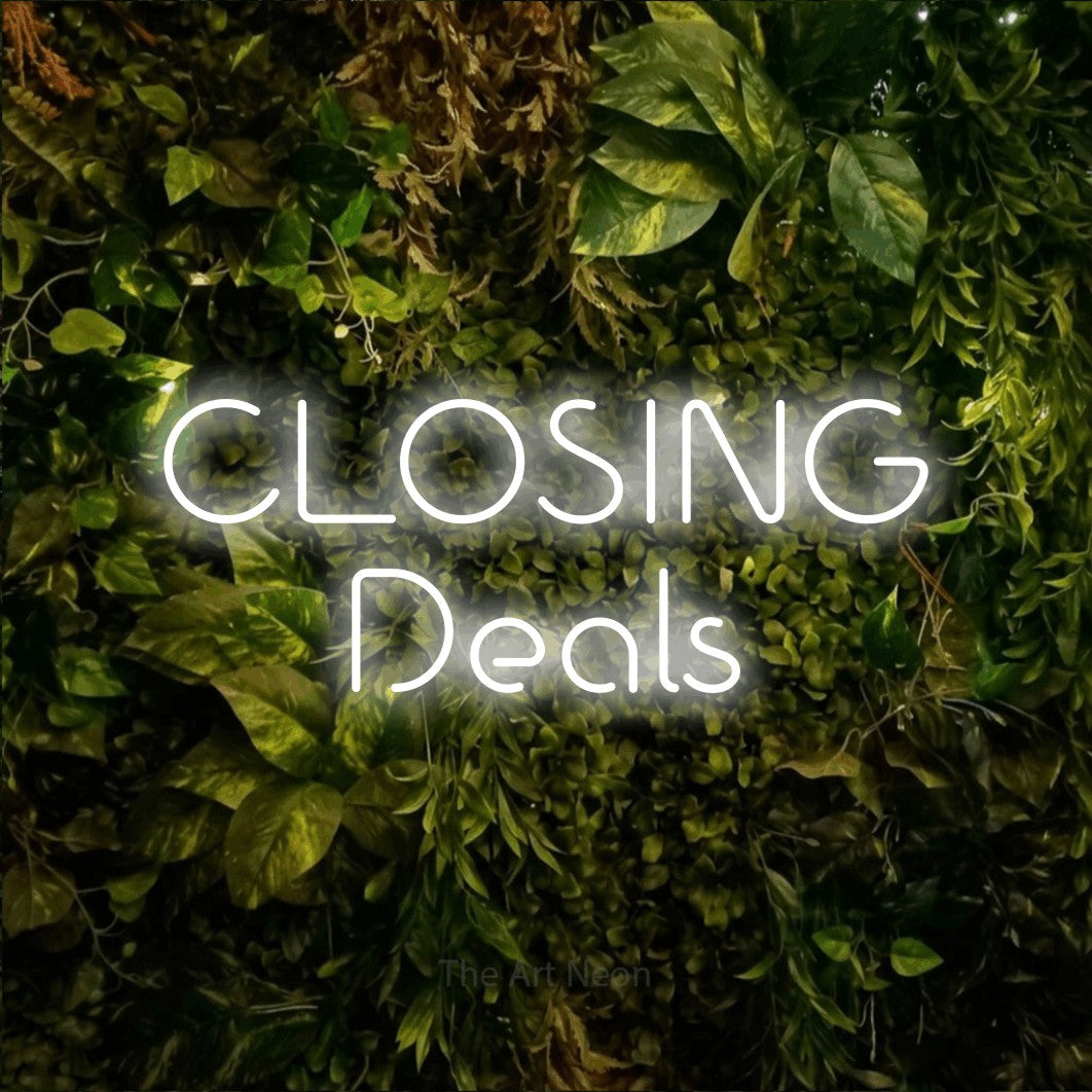 Cool white LED neon sign reading "Closing Deals" against a textured moss and foliage wall for office décor