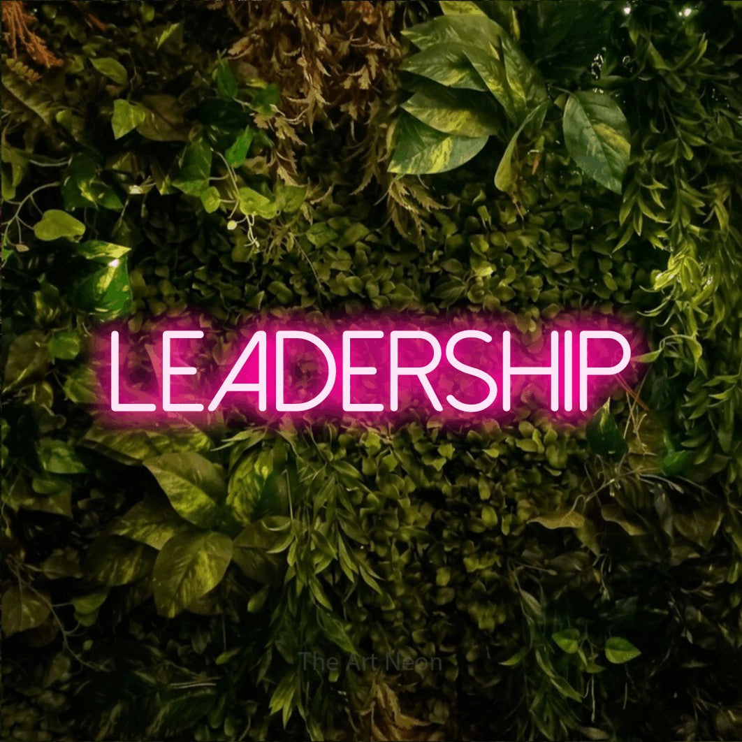 Hot pink LED neon sign reading "Leadership" against a textured moss and foliage wall for office décor