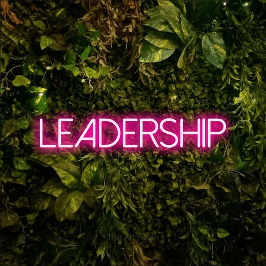 Enseigne néon à DEL à lumière rose vif, affichant « Leadership » sur un mur texturé de mousse et de feuillage, pour décorer un bureau