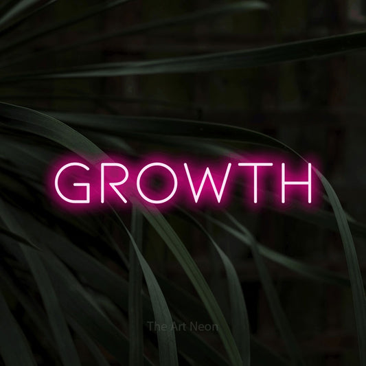 Hot pink LED neon sign reading "Growth" against dark tropical leaves for office décor
