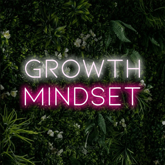 Hot pink and cool white LED neon sign reading "Growth Mindset" against a leafy green wall for office décor