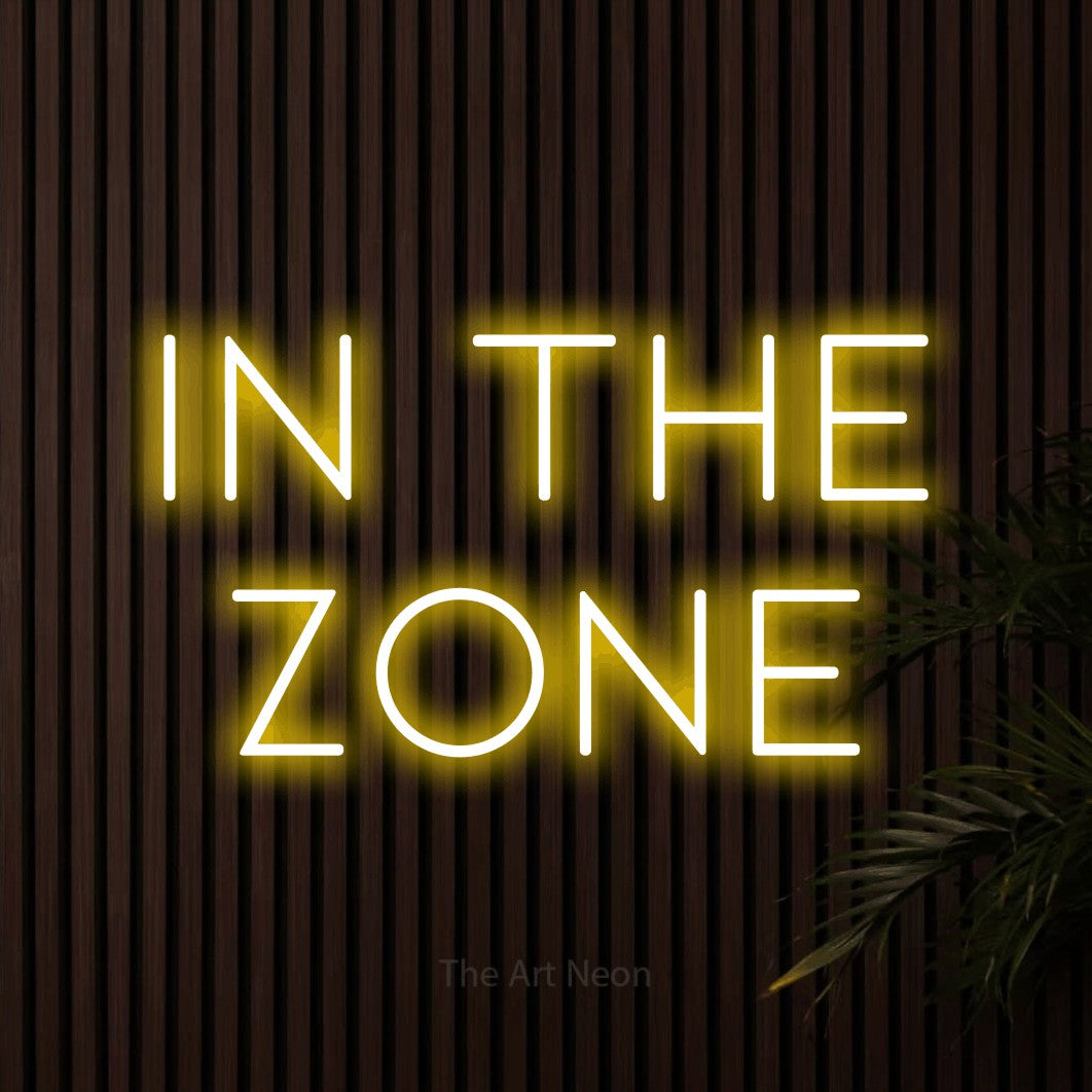 Yellow LED neon sign reading "In the Zone" against dark wooden slats for office décor