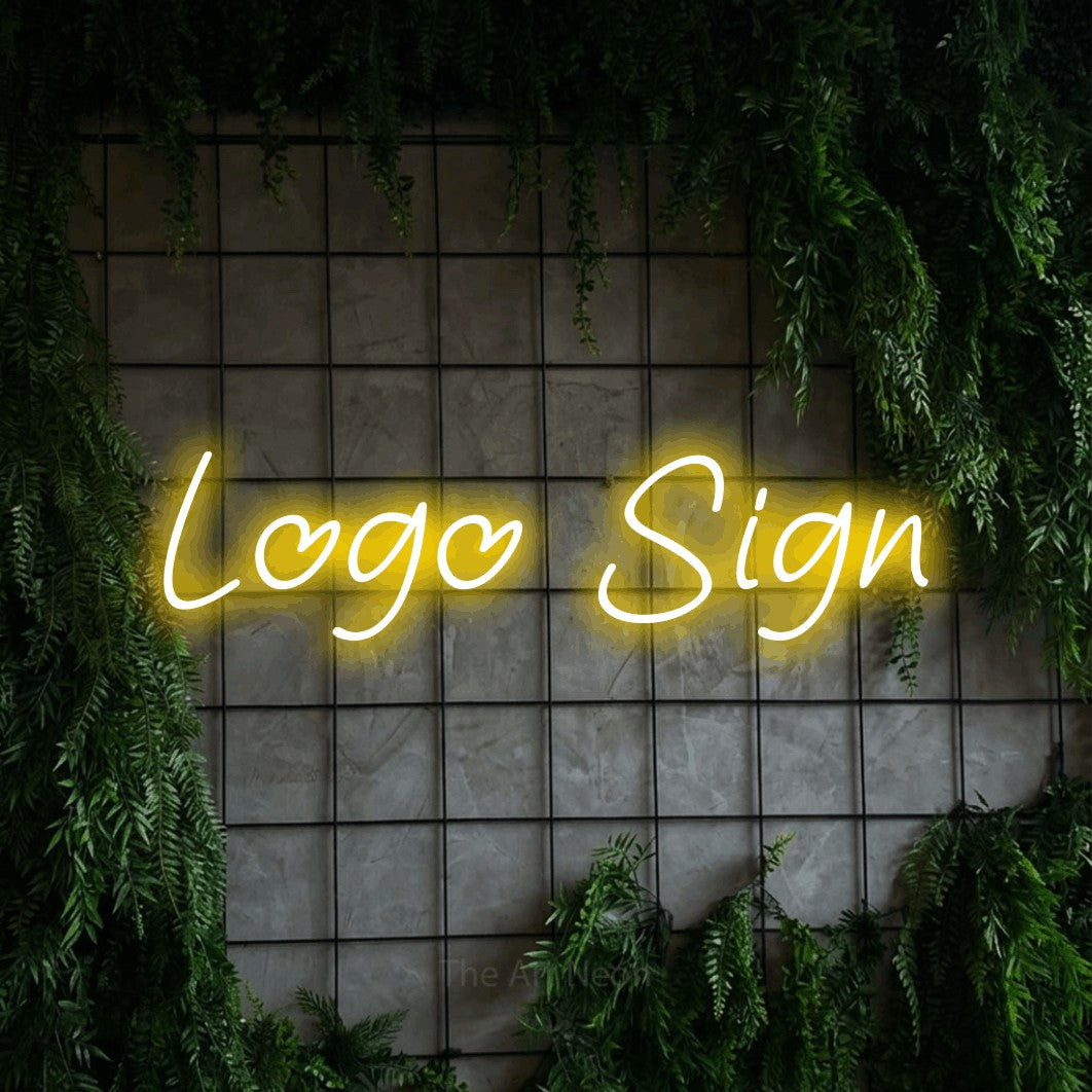 Yellow LED neon sign reading "Logo" against a green grid wall with foliage for office décor