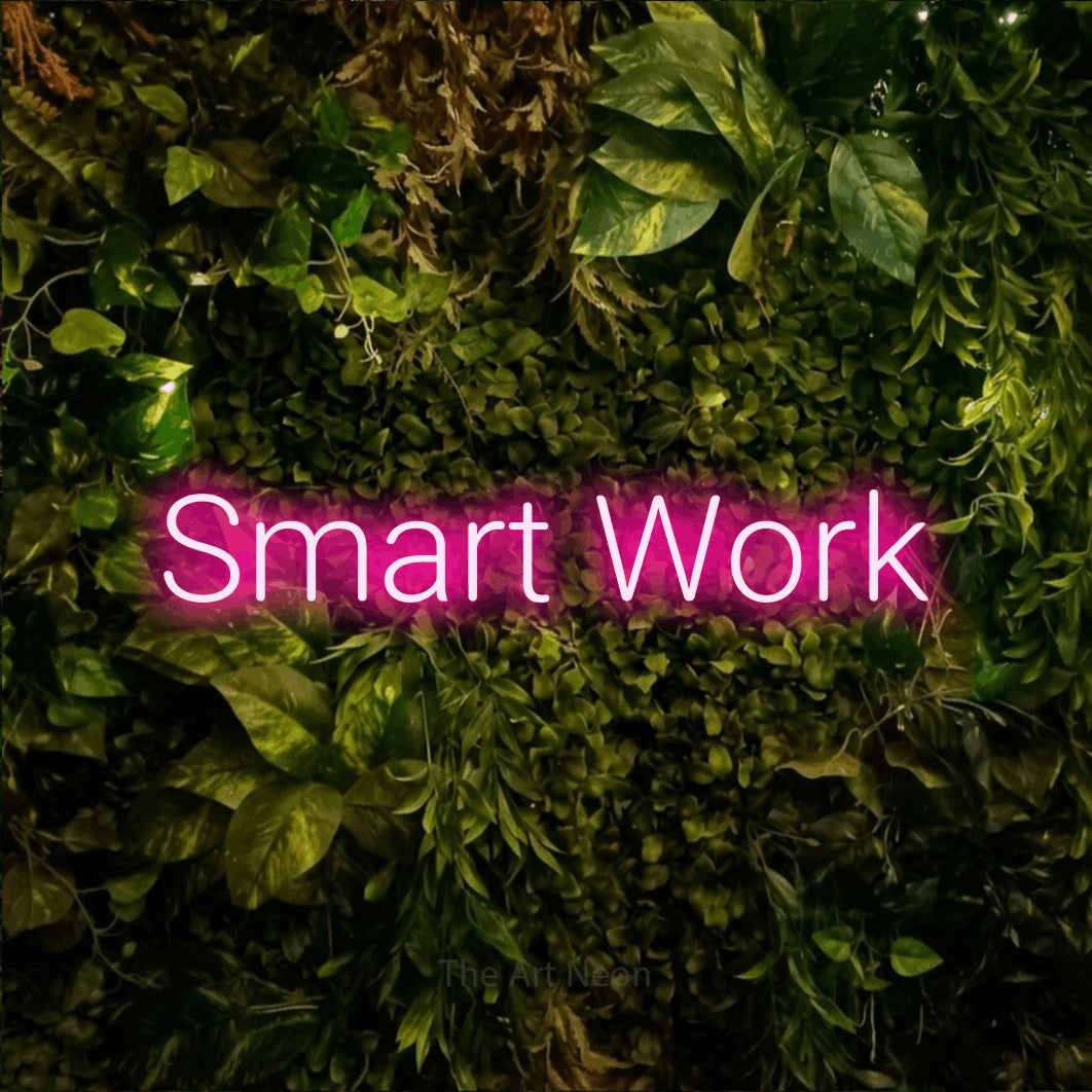 Hot pink LED neon sign reading "Smart Work" against a textured moss and foliage wall for office décor