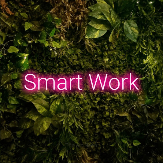 Hot pink LED neon sign reading "Smart Work" against a textured moss and foliage wall for office décor