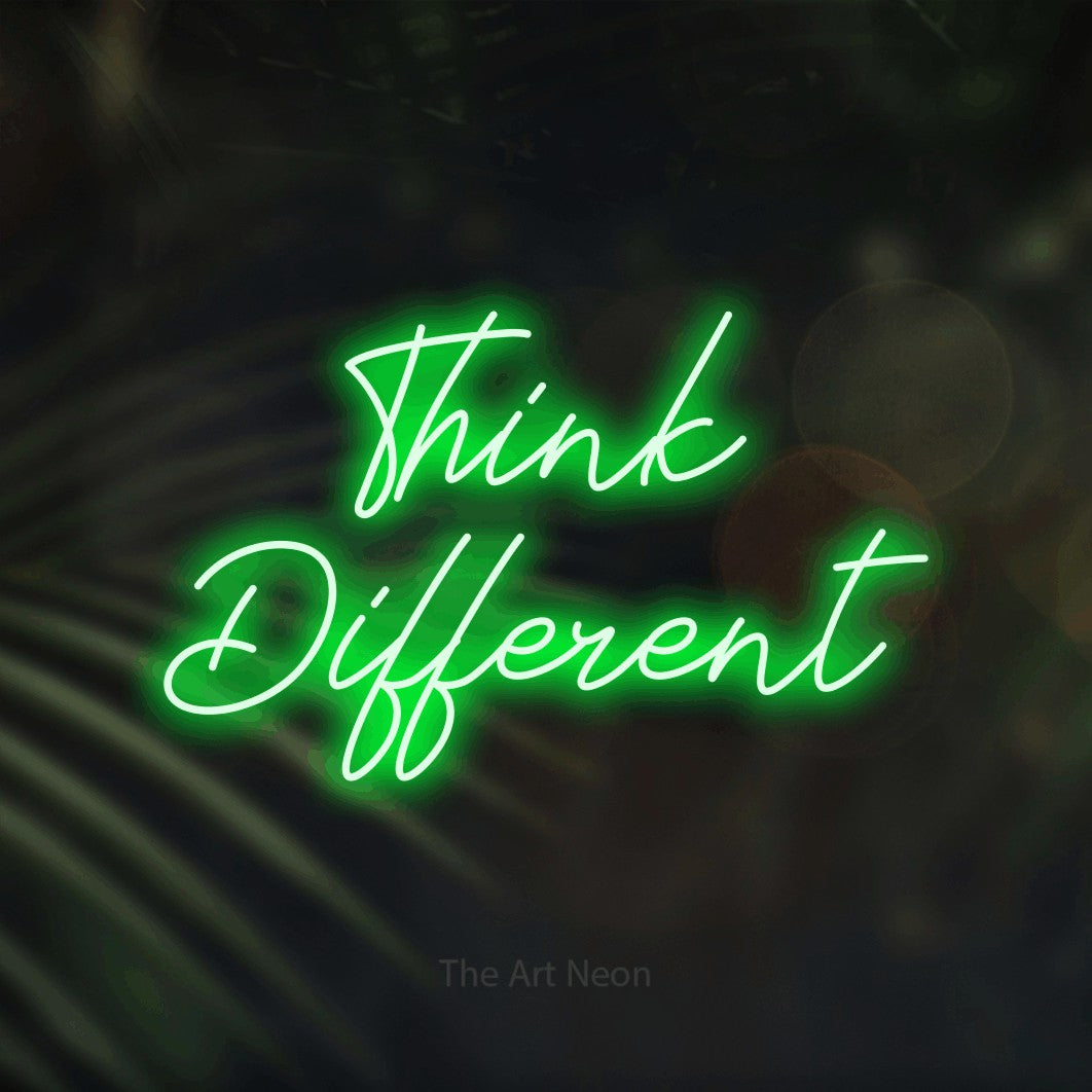 Enseigne néon à DEL à lumière verte, de style manuscrit, affichant « Think Different » sur des feuilles de palmier foncées et floues, pour décorer un bureau