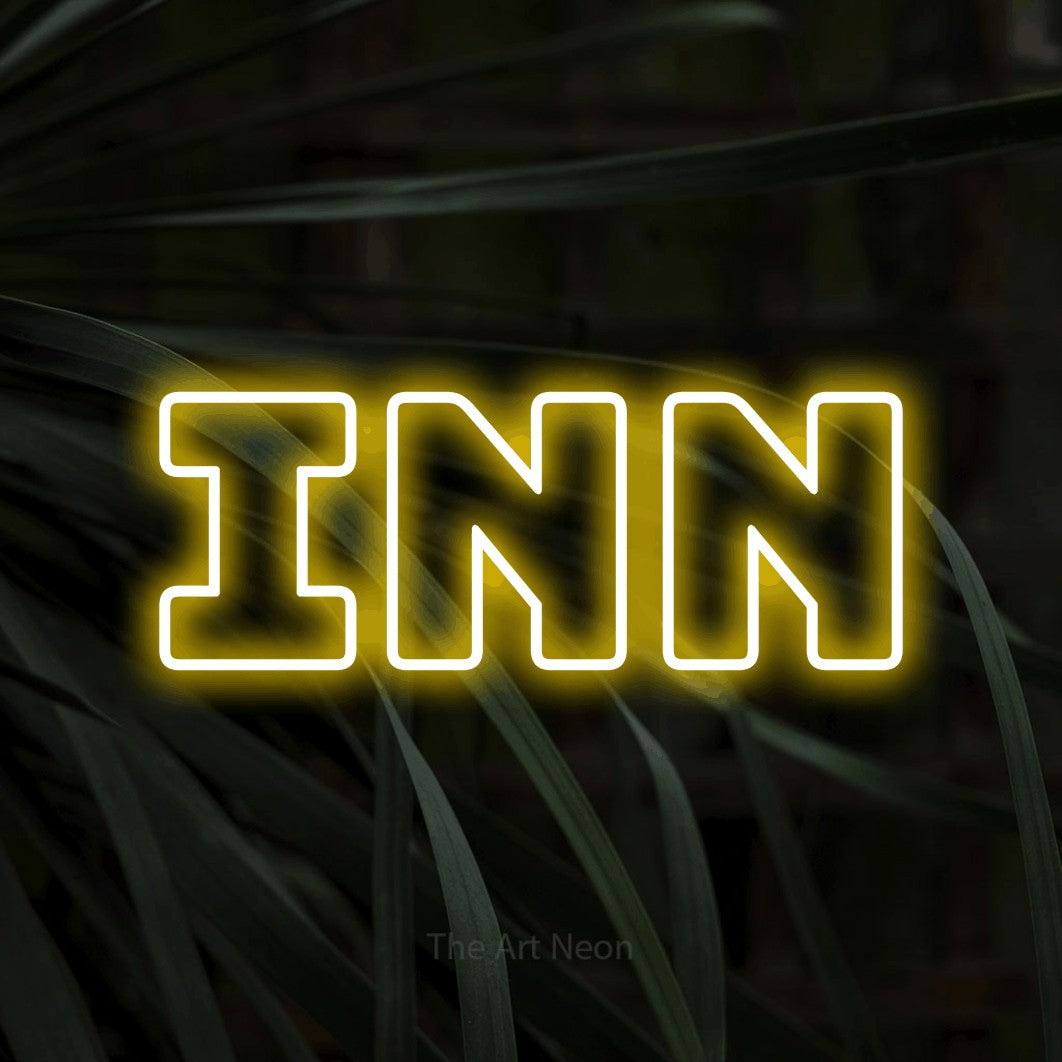 Enseigne néon à DEL à lumière jaune, de style contour, affichant « Inn » sur des feuilles tropicales foncées, pour décorer un hôtel