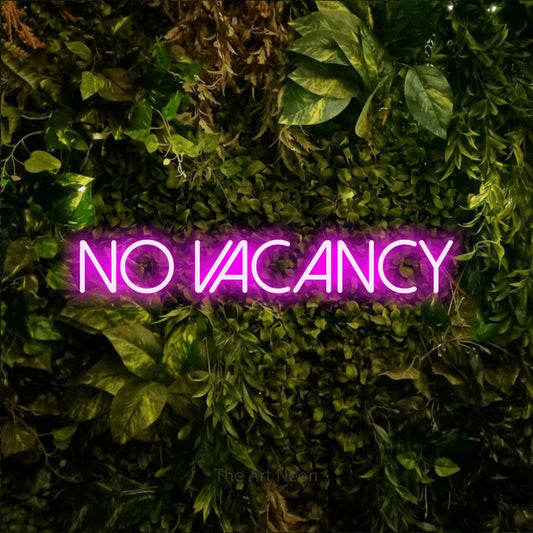 Pink LED neon sign reading "No Vacancy" against a textured moss and foliage wall for hotel décor