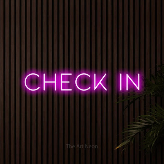 Pink LED neon sign reading "Check In" against dark wooden slats for hotel décor