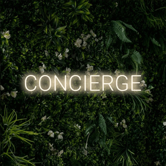 Warm white LED neon sign reading "Concierge" against a leafy green wall for hotel décor