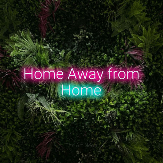 Ice blue and hot pink LED neon sign reading "Home Away from Home" against a lush garden wall with pink flowers
