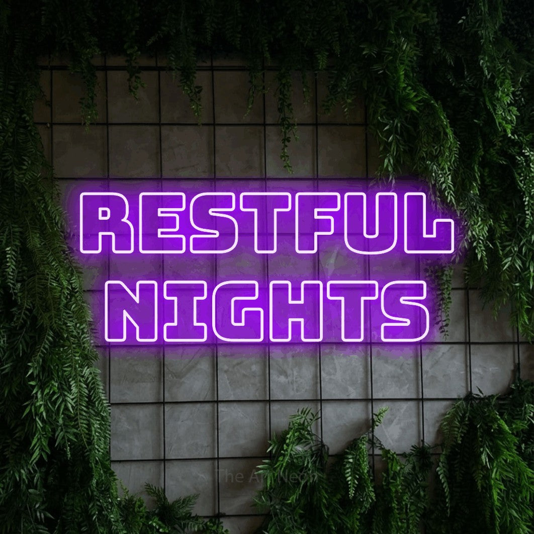 Purple outline-style LED neon sign reading "Restful Nights" against a green grid wall with foliage for hotel décor