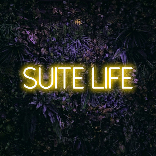 Yellow LED neon sign reading "Suite Life" against a purple floral wall for hotel décor