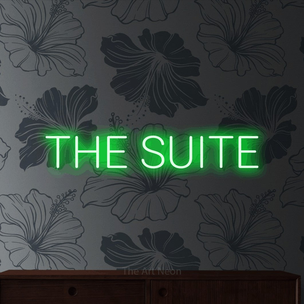 Green LED neon sign reading "The Suite" against grey floral wallpaper for hotel décor
