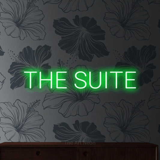 Green LED neon sign reading "The Suite" against grey floral wallpaper for hotel décor