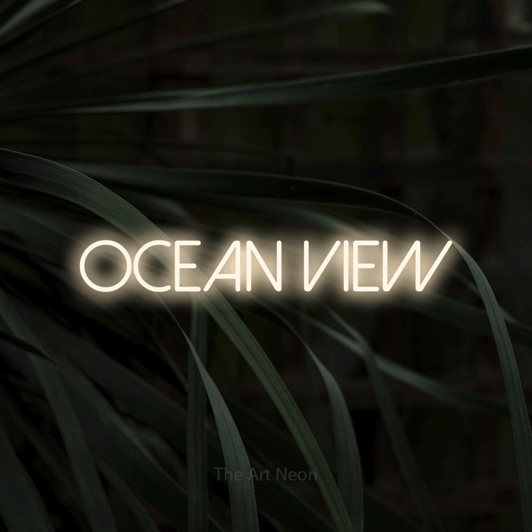 Warm white LED neon sign reading "Ocean View" against dark tropical leaves for hotel décor