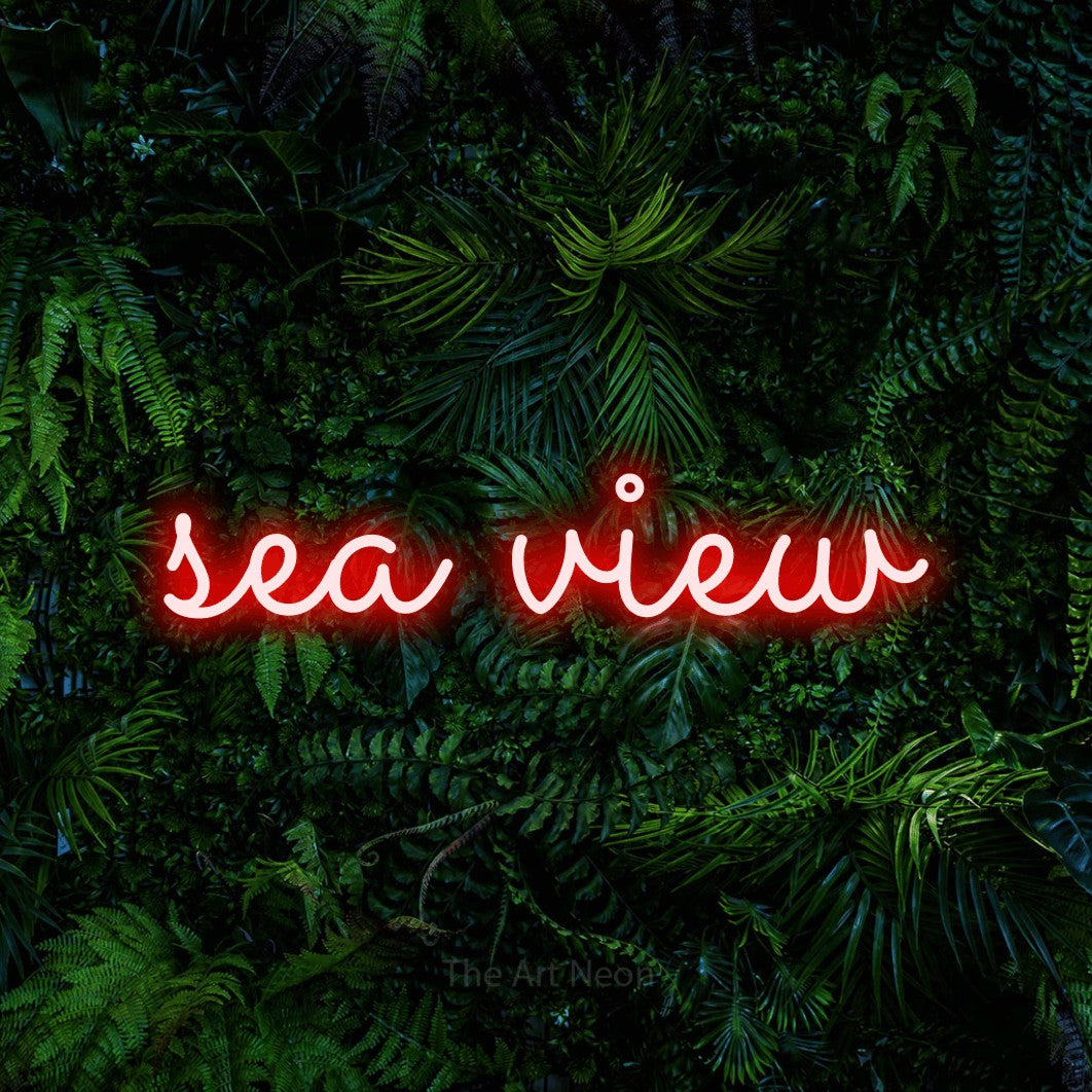 Red LED neon sign reading "Sea View" against a dense tropical foliage wall for hotel décor