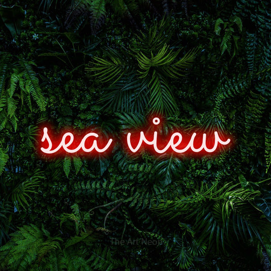 Red LED neon sign reading "Sea View" against a dense tropical foliage wall for hotel décor