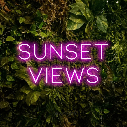 Pink LED neon sign reading "Sunset Views" against a textured moss and foliage wall for hotel décor