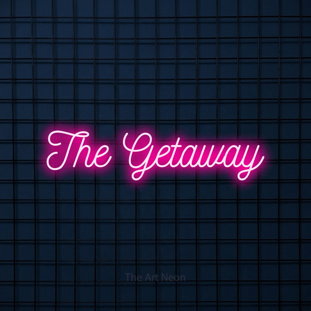 Hot pink script-style LED neon sign reading "The Getaway" against a dark blue tiled wall for hotel décor