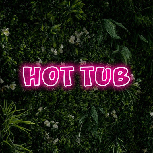 Hot pink outline-style LED neon sign reading "Hot Tub" against a leafy green wall for hotel décor