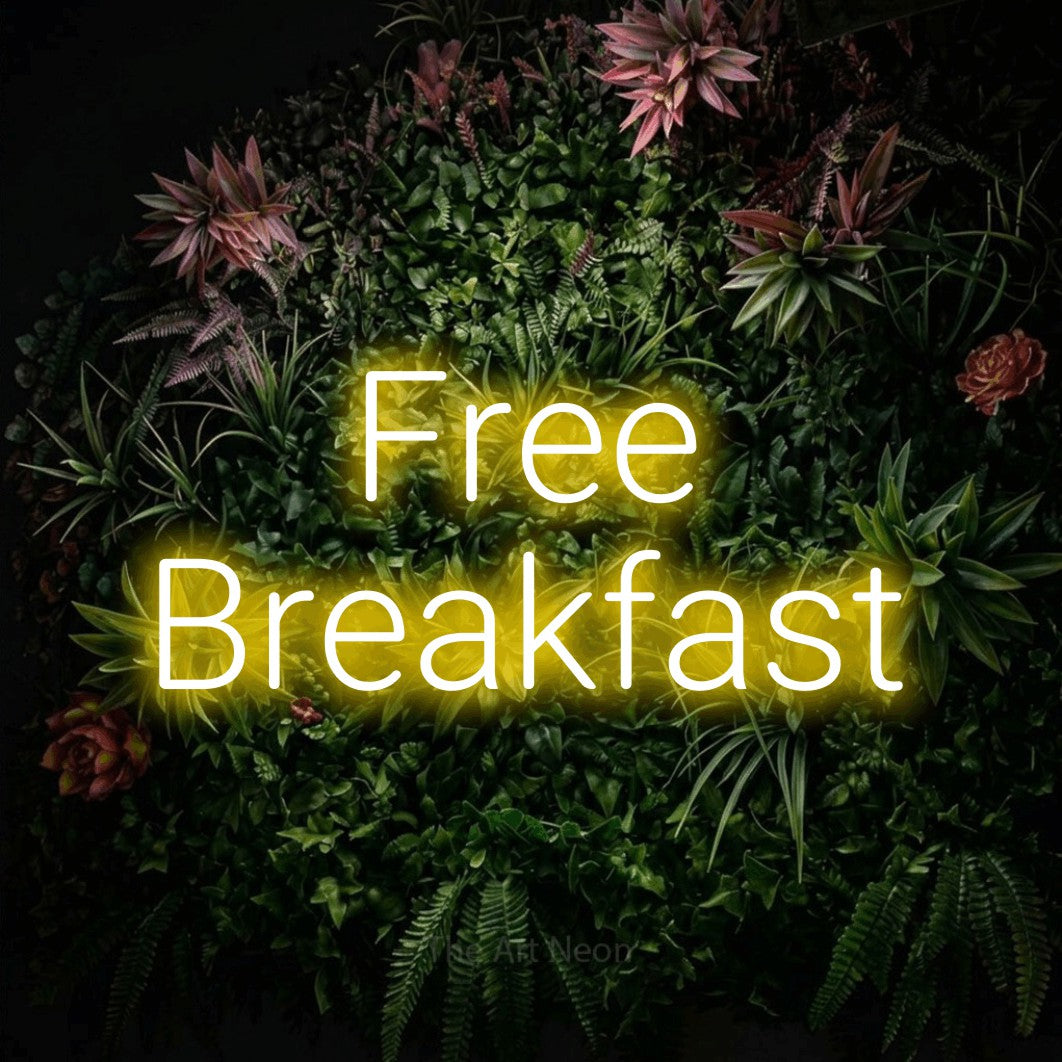 Yellow LED neon sign reading "Free Breakfast" against a flowering garden wall for hotel décor