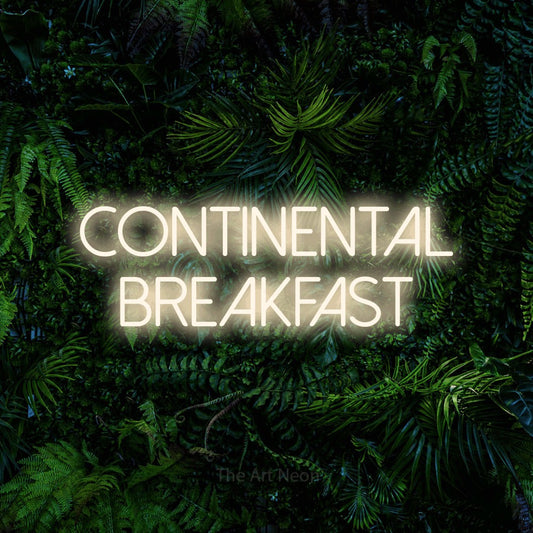 Warm white LED neon sign reading "Continental Breakfast" against a dense tropical foliage wall for hotel décor